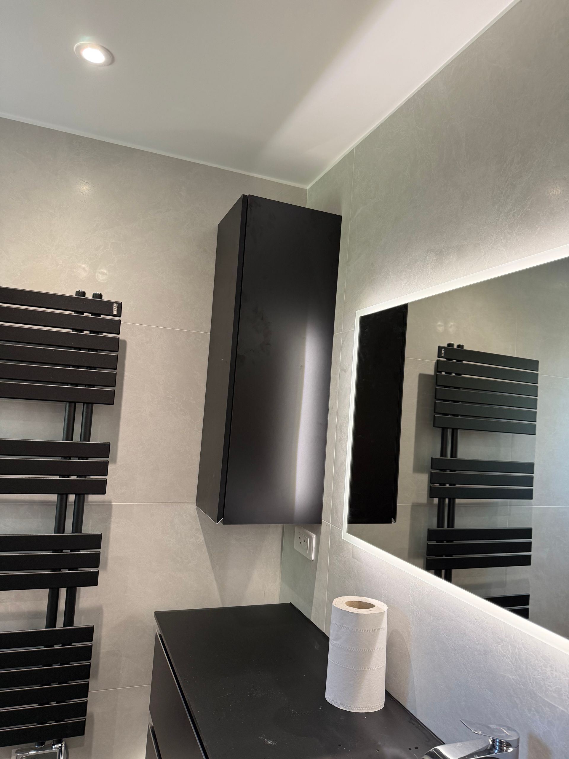 Miroir lumineux avec meuble vasque noir et radiateur sèche-serviettes