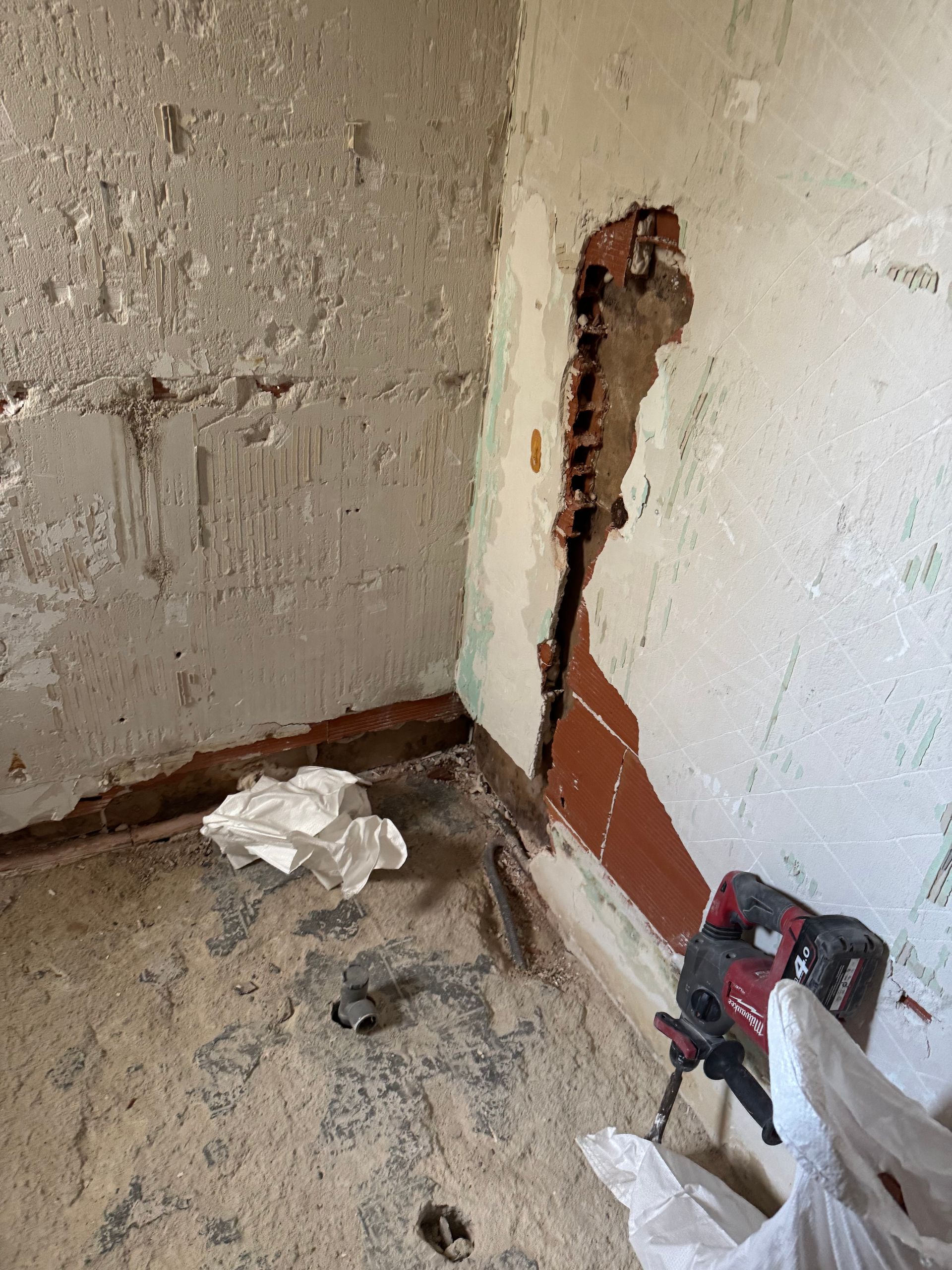 Démolition d’un mur avec tuyauterie exposée