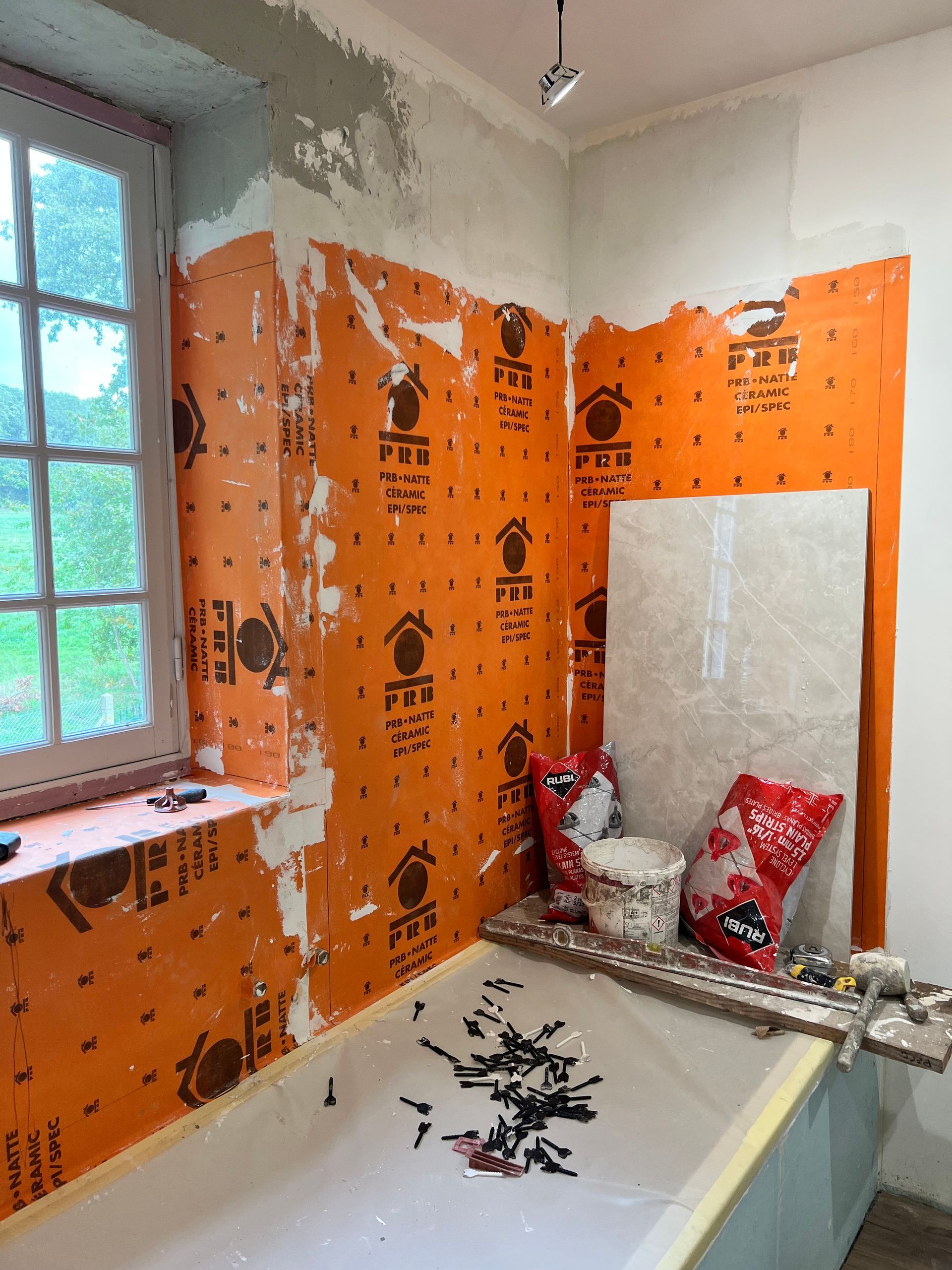 Bâche de protection sur une baignoire avec des outils posés dessus