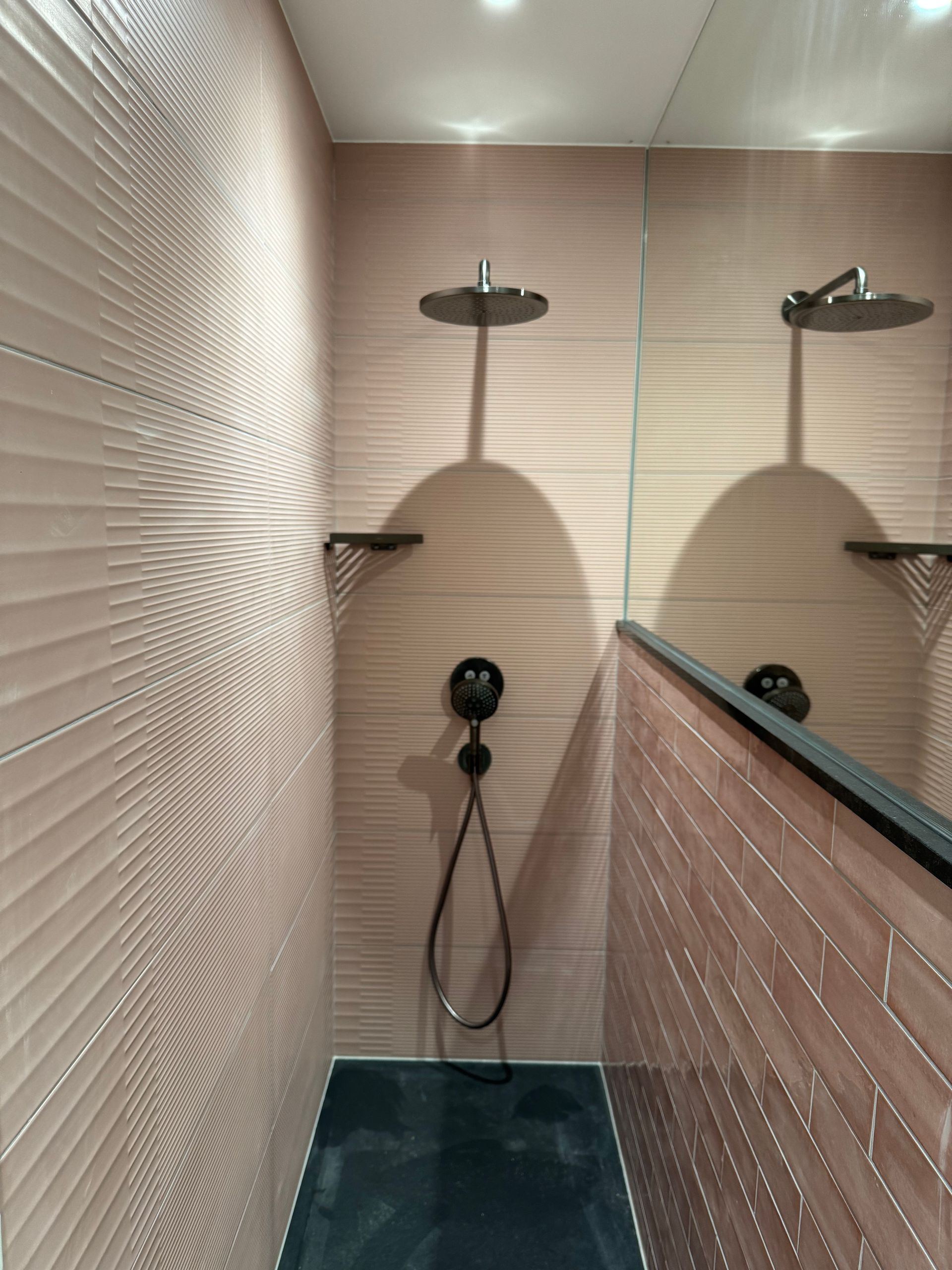 Douche italienne avec du carrelage jusqu'au plafond et un grand miroir