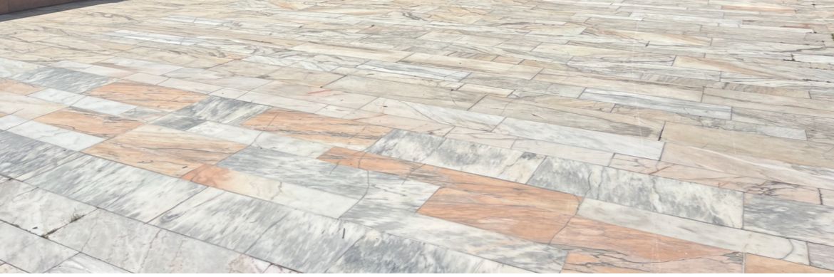 Pavés de briques de différentes nuances de gris et d'orange posés en quinconce.