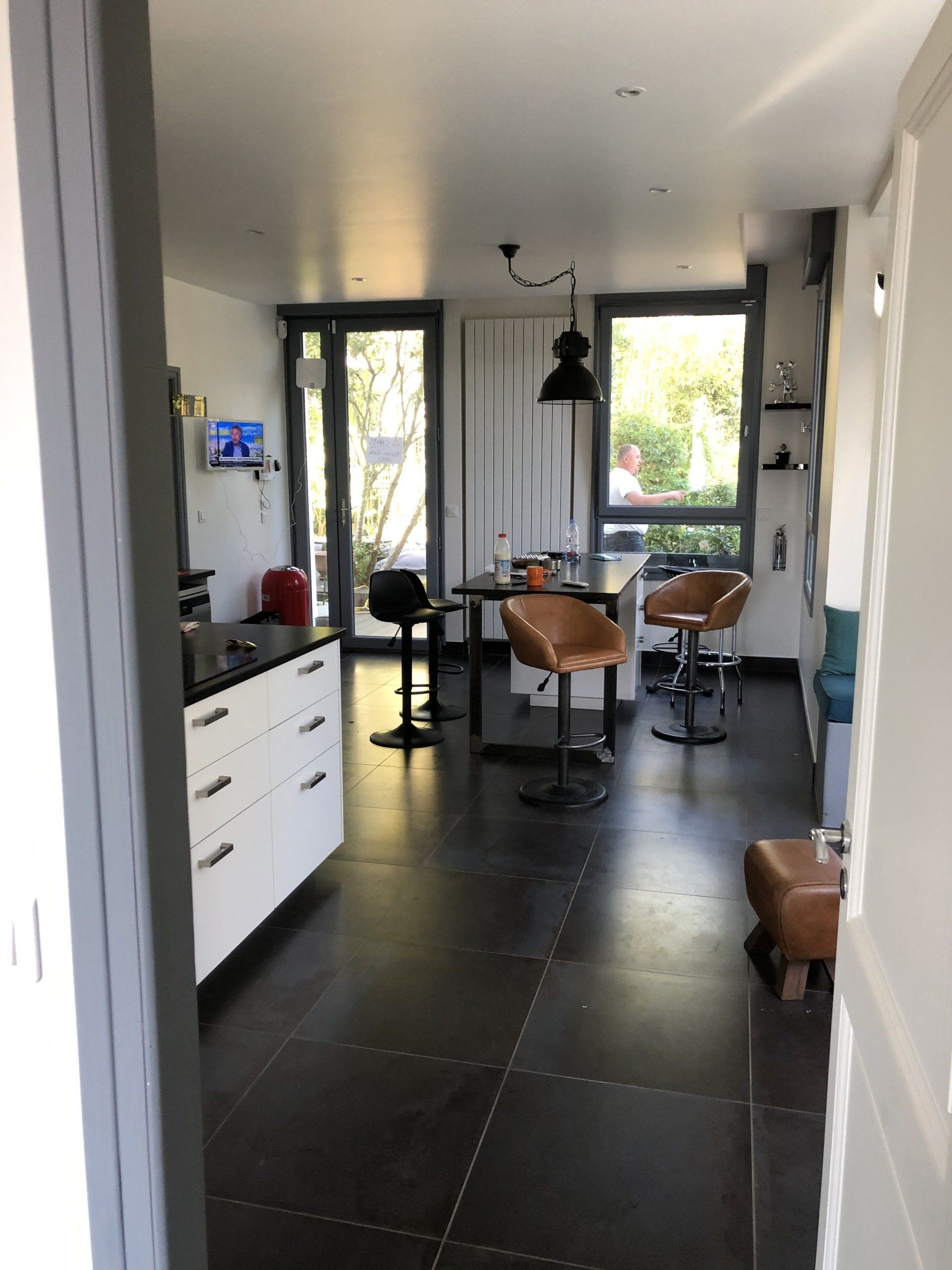 Aménagement de la cuisine avec îlot central et pose de grands carreaux grès cérame