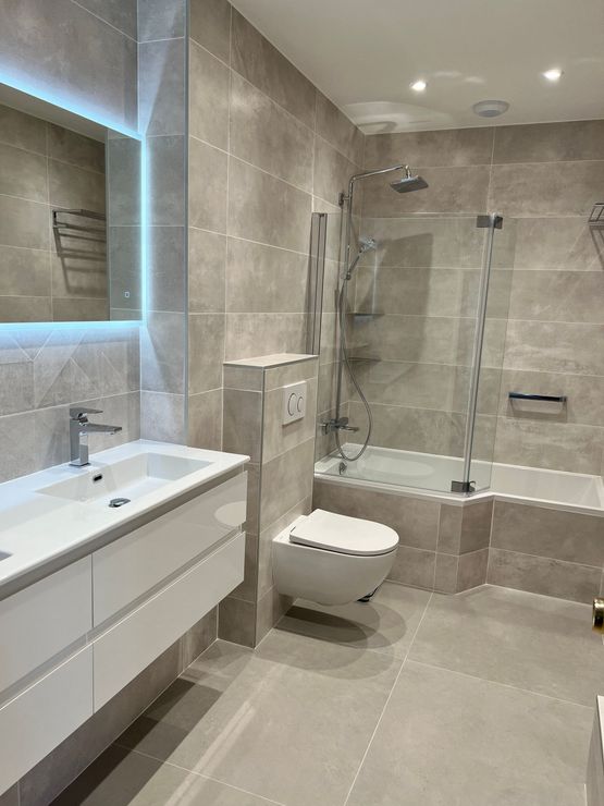 Deux ouvriers répandent des granulés foncés sur le sol d'une pièce en construction.