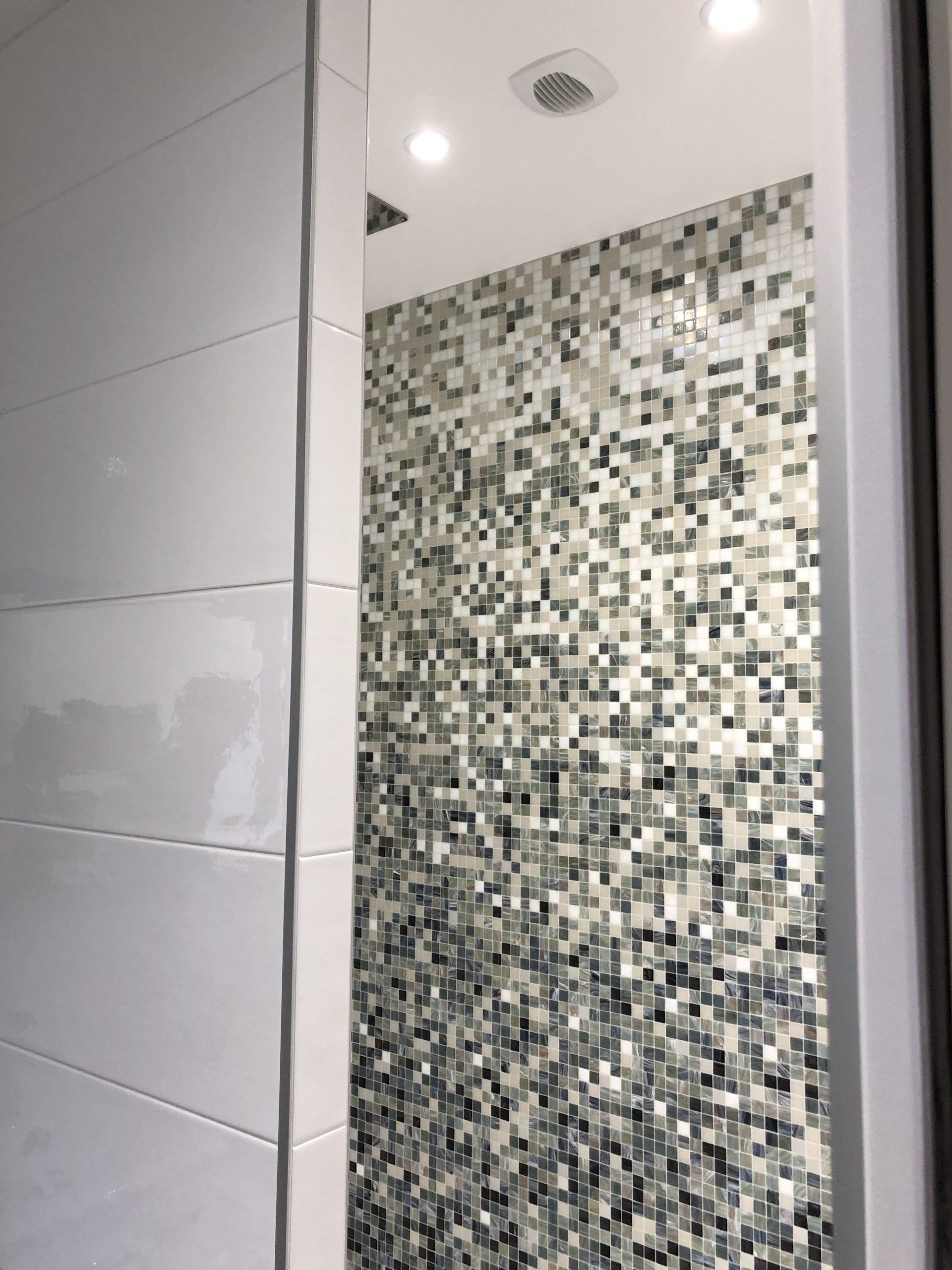 Mur de douche avec des petits carreaux de plusieurs couleurs