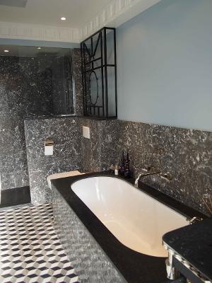 Baignoire au contour noir avec une décoration murale en marbre