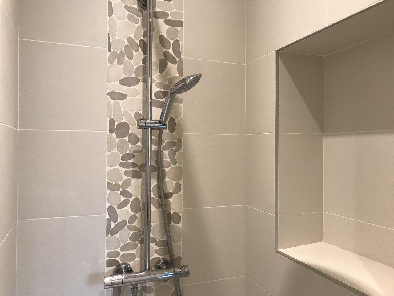 Derrière de colonne de douche décoré avec des galets marron
