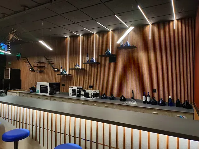 Una cocina con una encimera larga y una pared de madera.