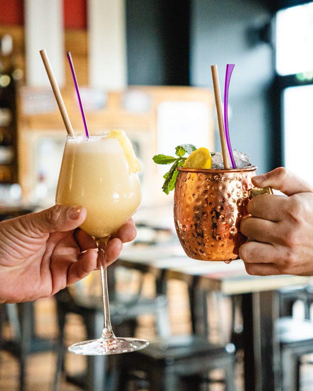 Des mains tenant des cocktails.