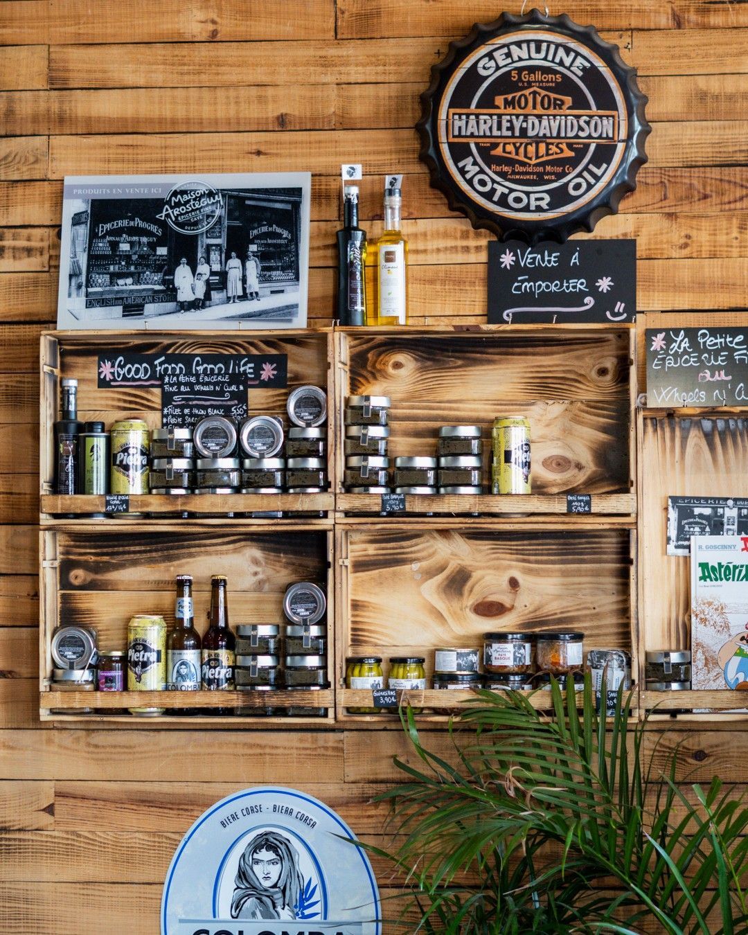 Étagères en bois avec produits, enseignes vintage, contre un mur lambrissé ; étalage de magasin.