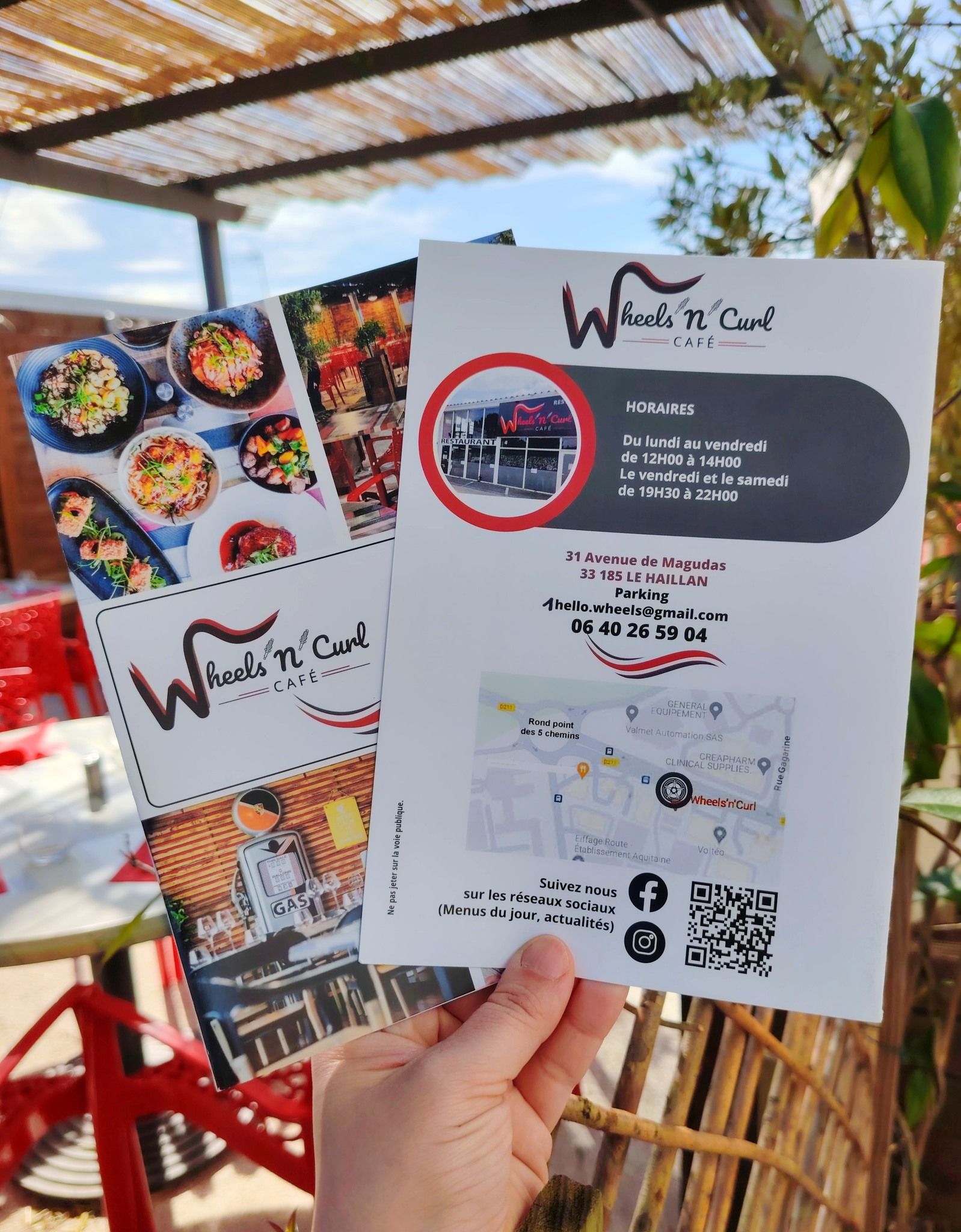 Des mains tiennent des cartes du restaurant.