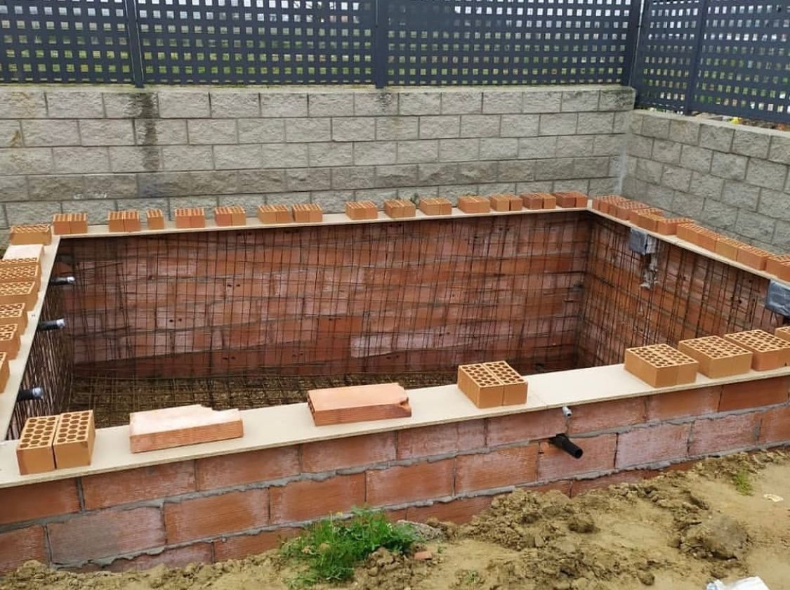 Se está construyendo un muro de ladrillos al lado de una valla