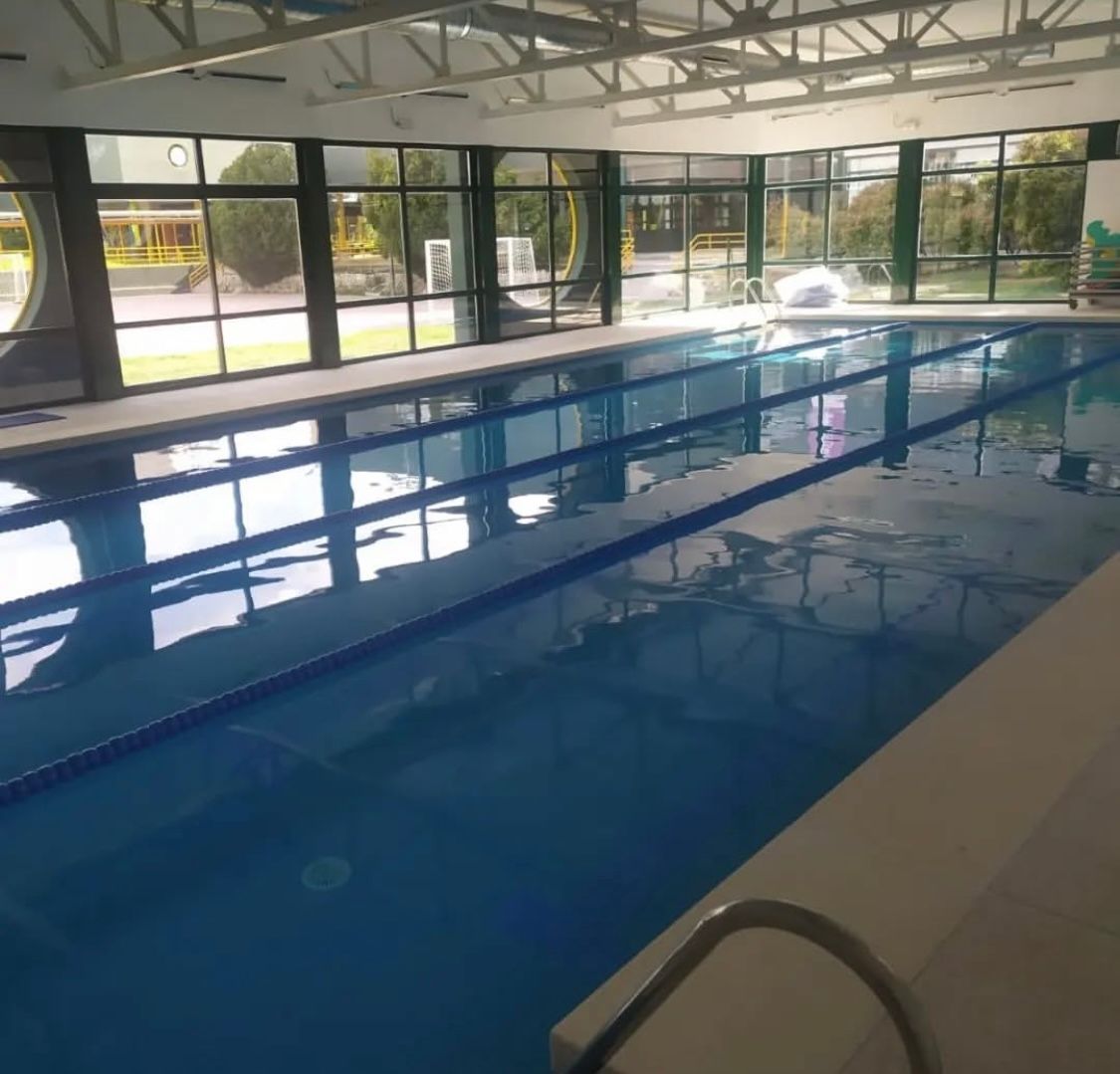 Una gran piscina cubierta con muchas ventanas.