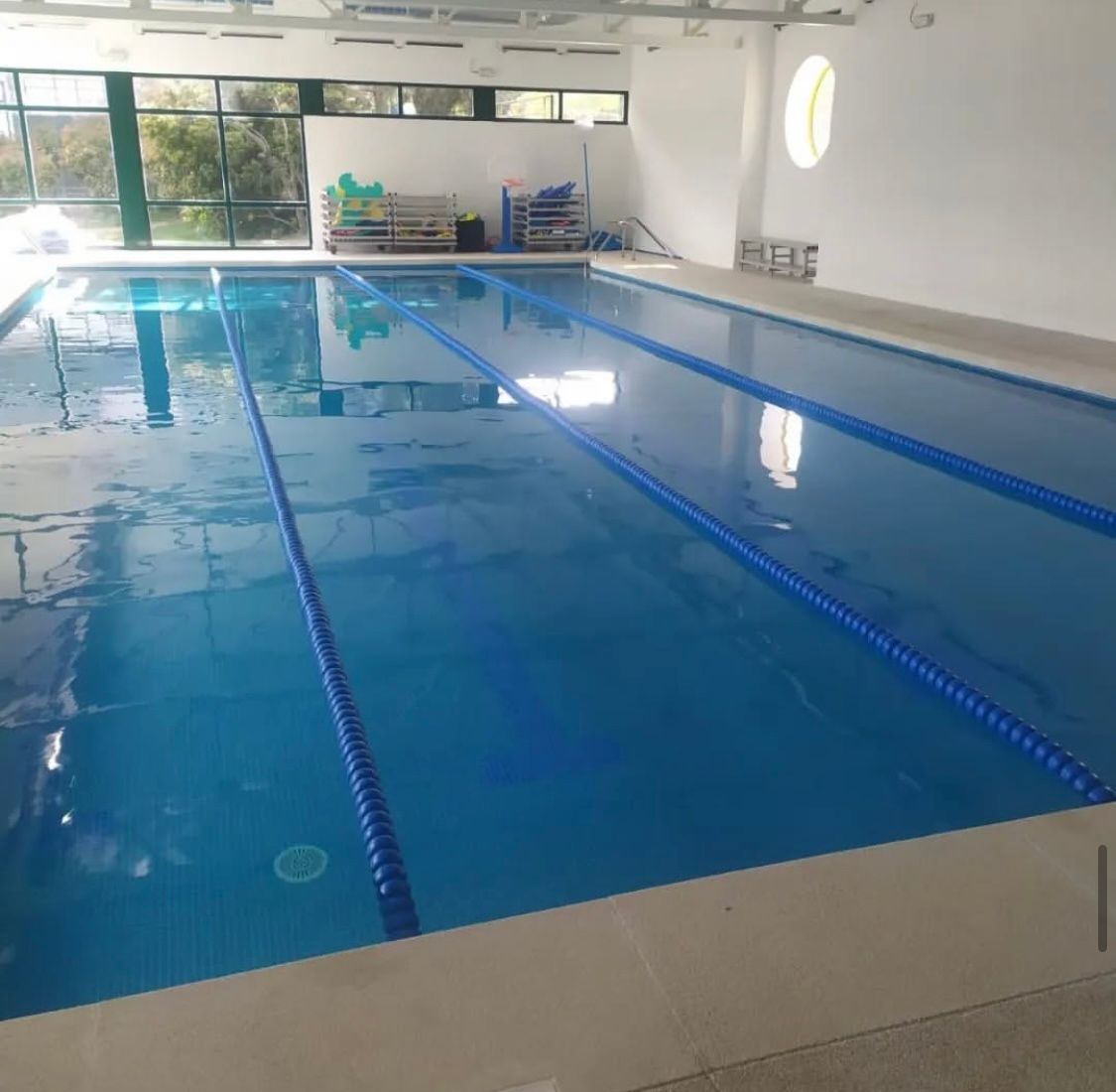 Una gran piscina cubierta con carriles azules