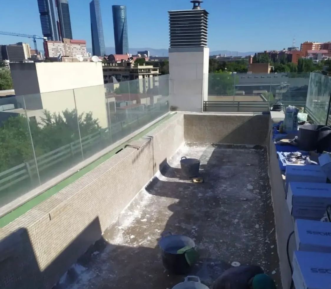 Un tejado con chimenea y una ciudad al fondo