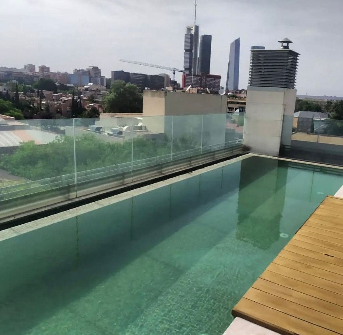 Una gran piscina con una ciudad al fondo.
