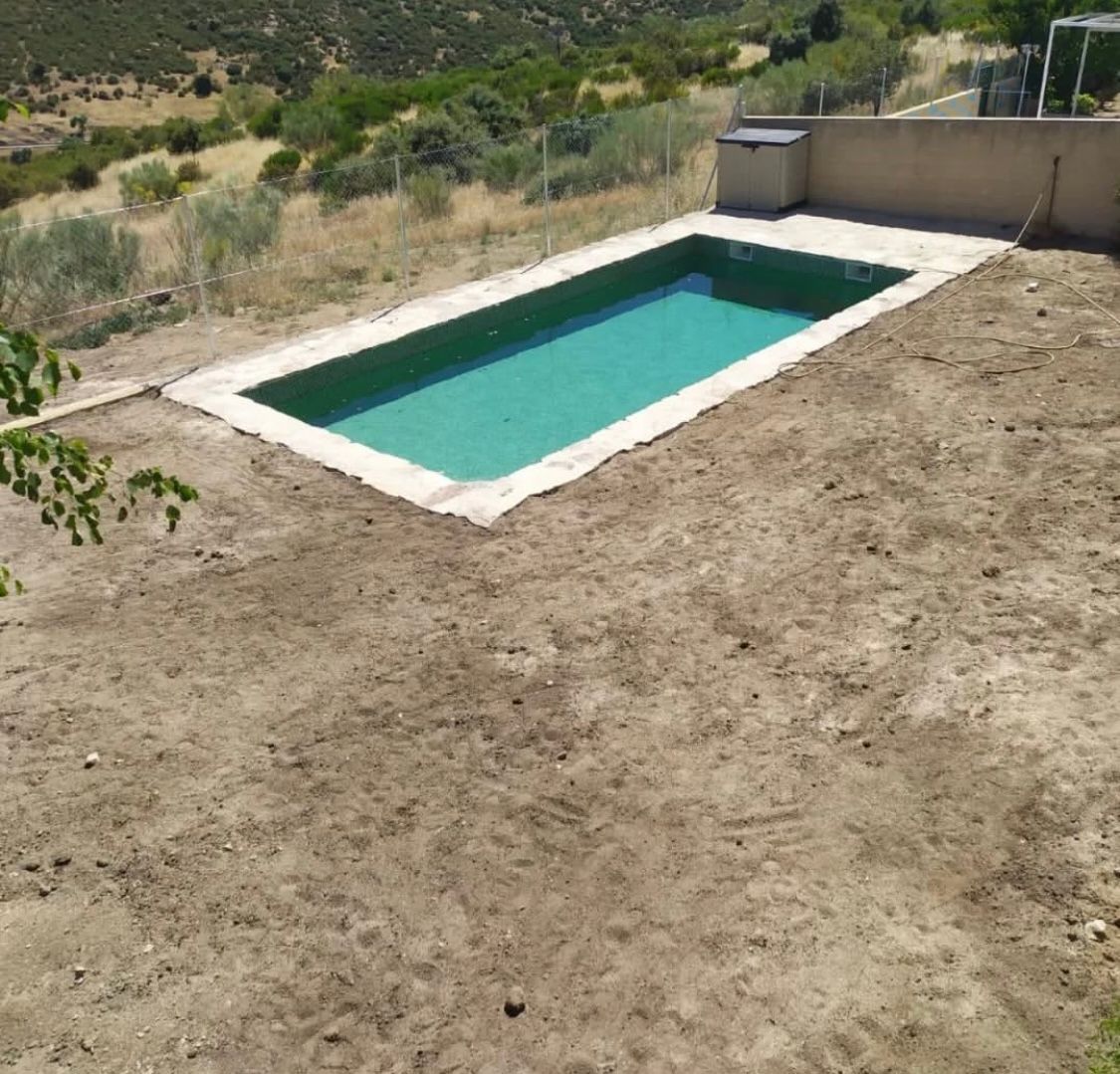 Una gran piscina en medio de un campo de tierra
