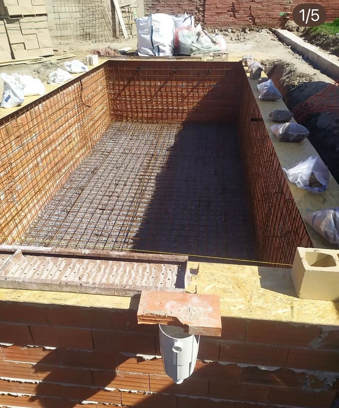 Se está construyendo un muro de ladrillos alrededor de una piscina.