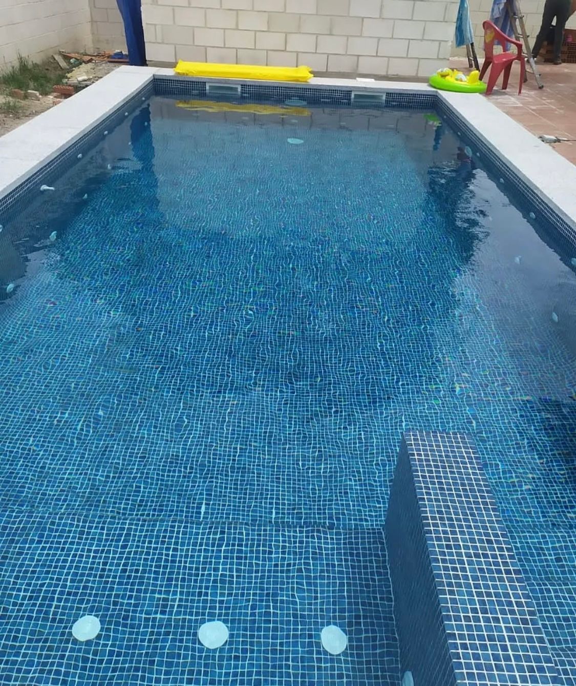 Una gran piscina con una balsa amarilla en ella