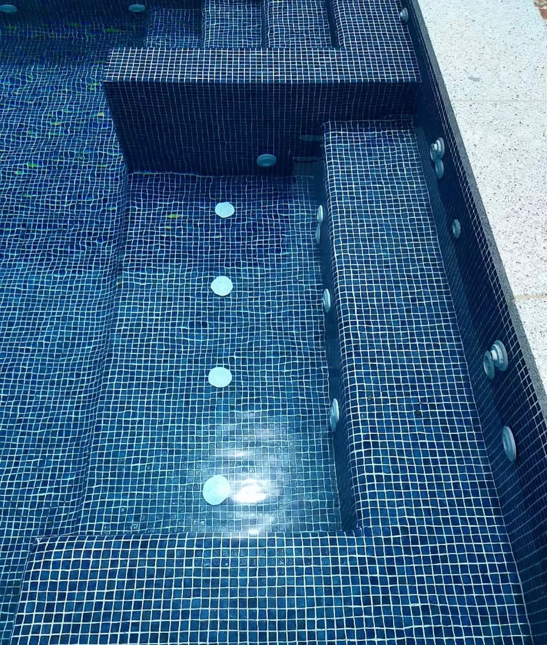 Un primer plano de una piscina con azulejos azules.
