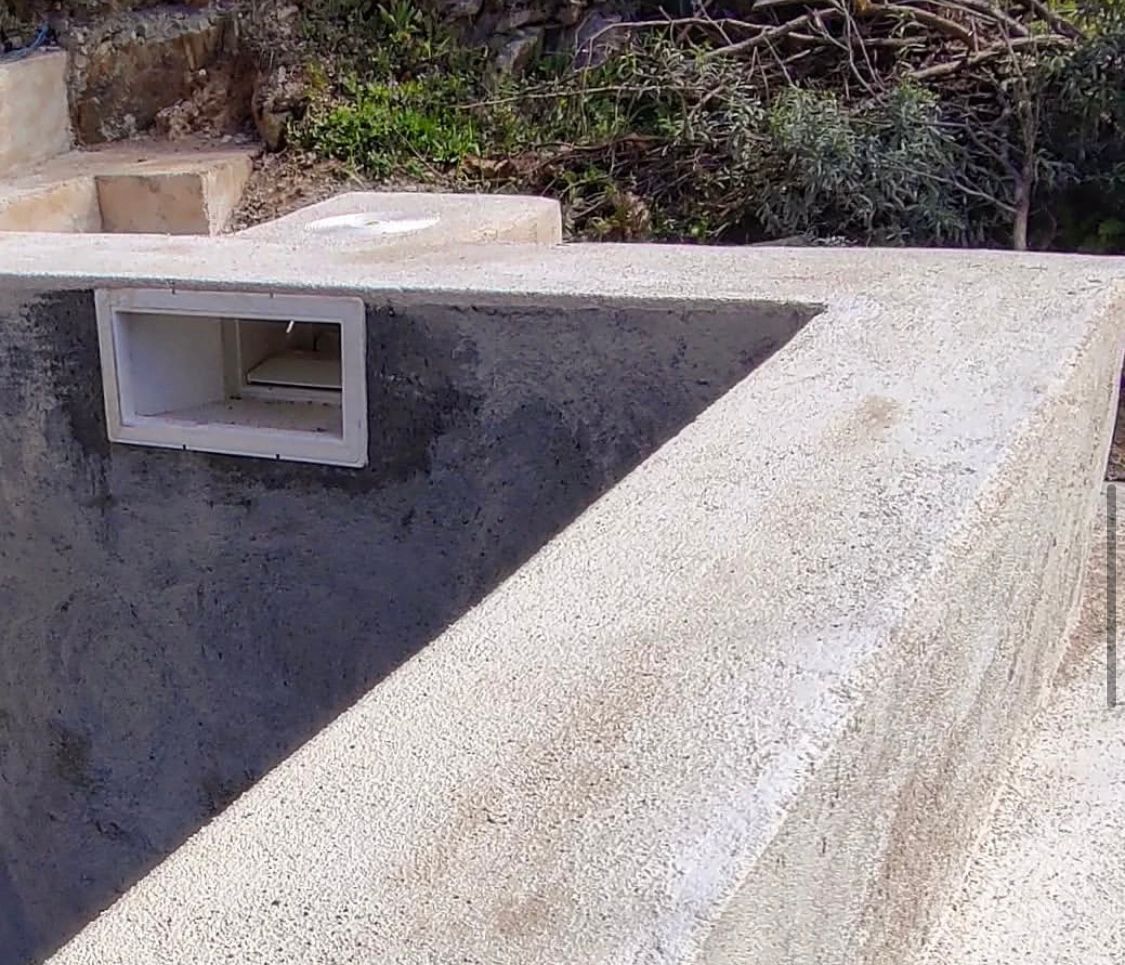 Un muro de hormigón que rodea una piscina con un agujero en él.