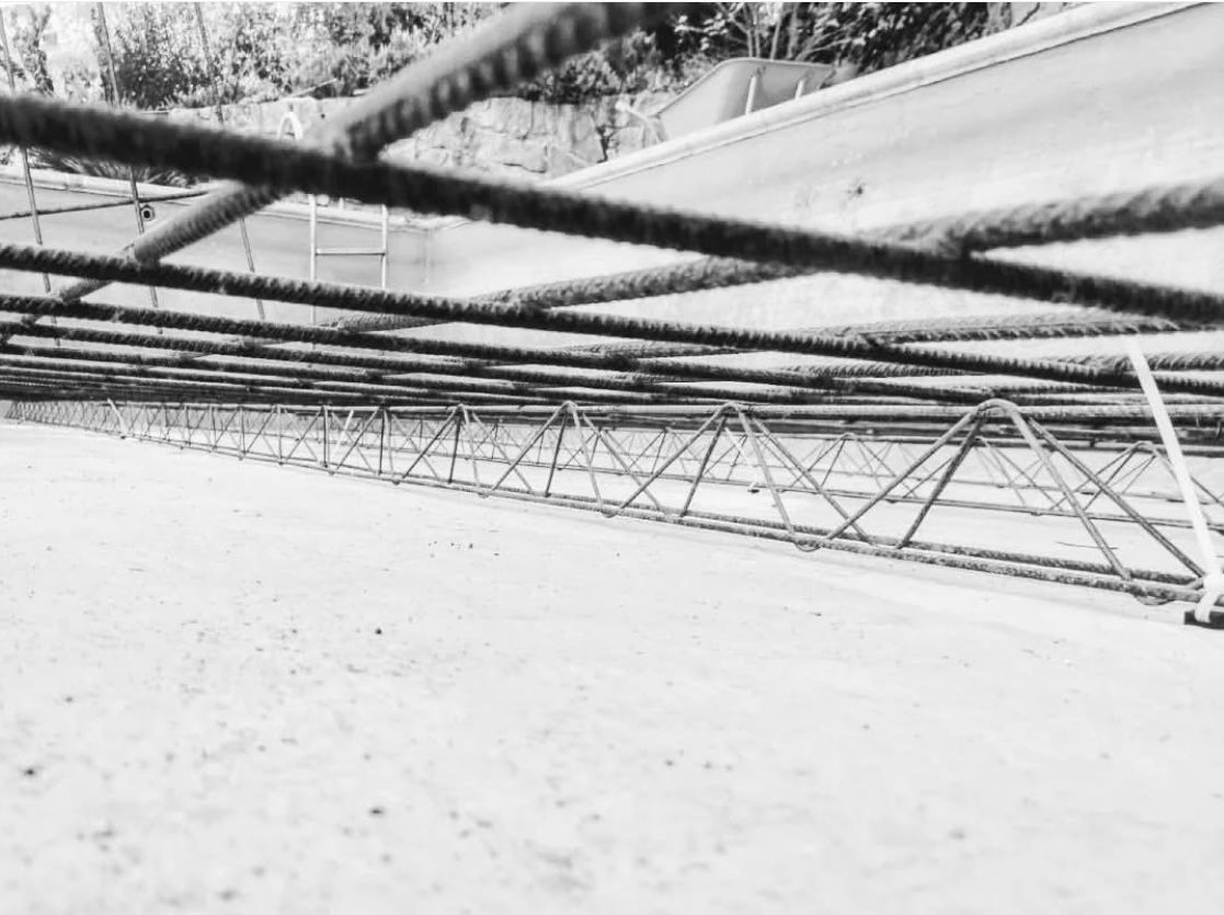 Una fotografía en blanco y negro de una estructura metálica sobre una superficie de hormigón.