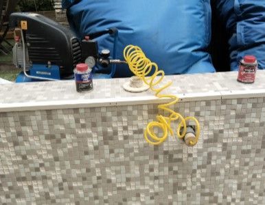 Un muro de hormigón que rodea una piscina con un agujero en él.