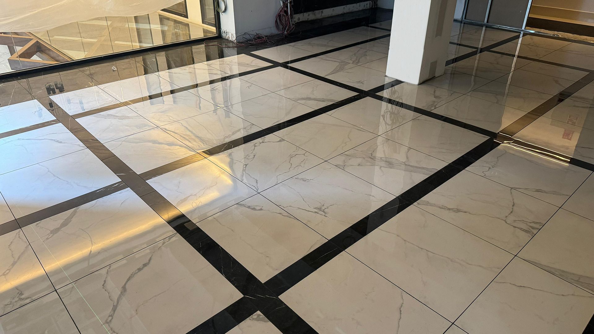 Suelo de mármol brillante con borde negro en un edificio moderno.