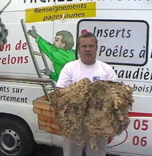 Le dirigeant qui tient dans les bras le plus gros nid de frelons qu'il a enlevé