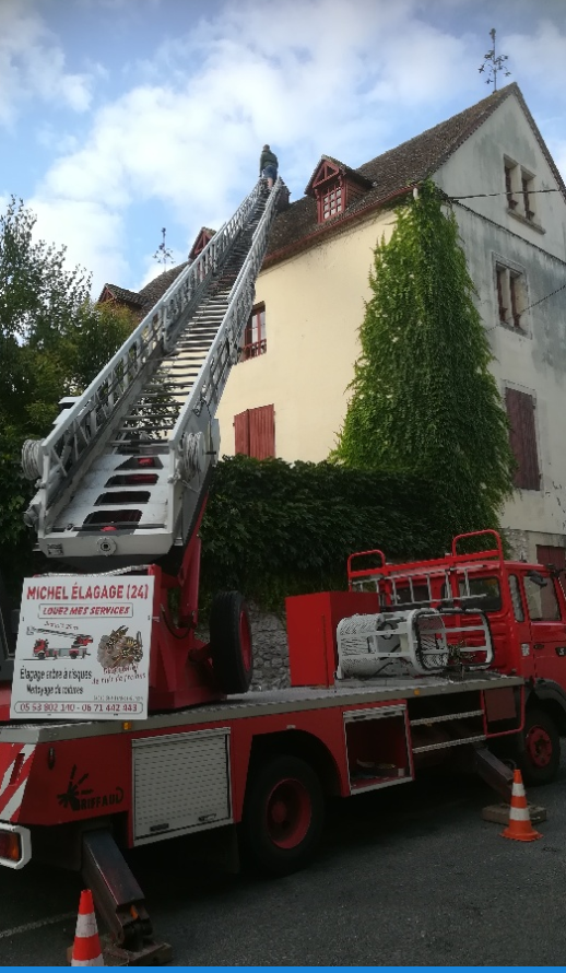 Photo du camion de l'entreprise avec la nacelle en haut d'un toit