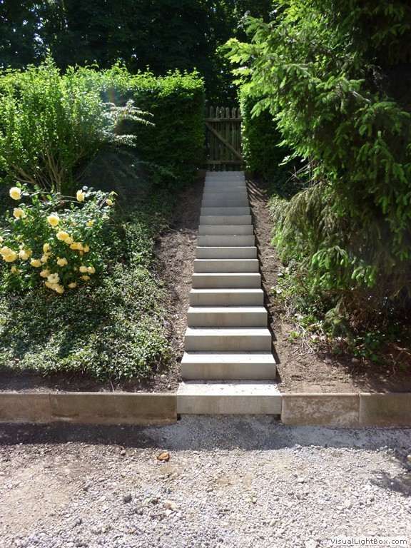Eine Treppe, die zu einem Tor in einem Garten führt