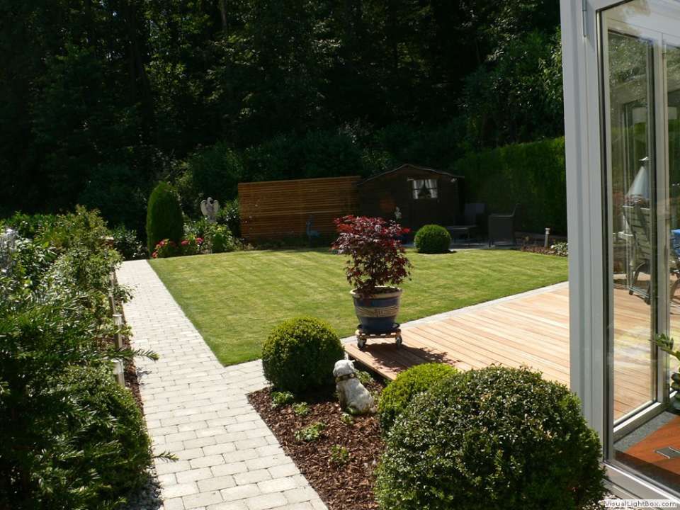 Ein Gehweg, der zu einem üppigen grünen Garten führt