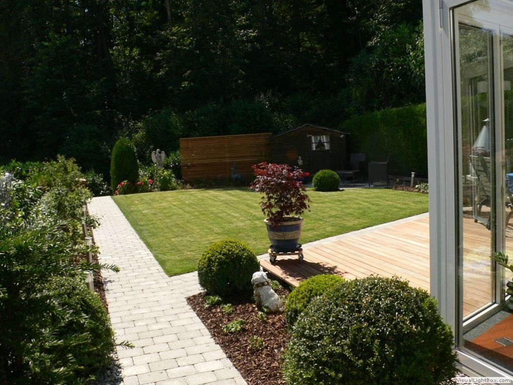 Ein Ziegelweg, der zu einem üppigen grünen Garten führt