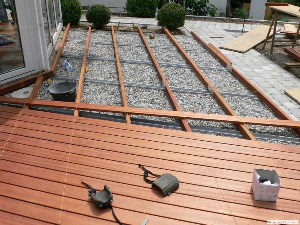 Auf einem Schotterboden entsteht ein Holzdeck