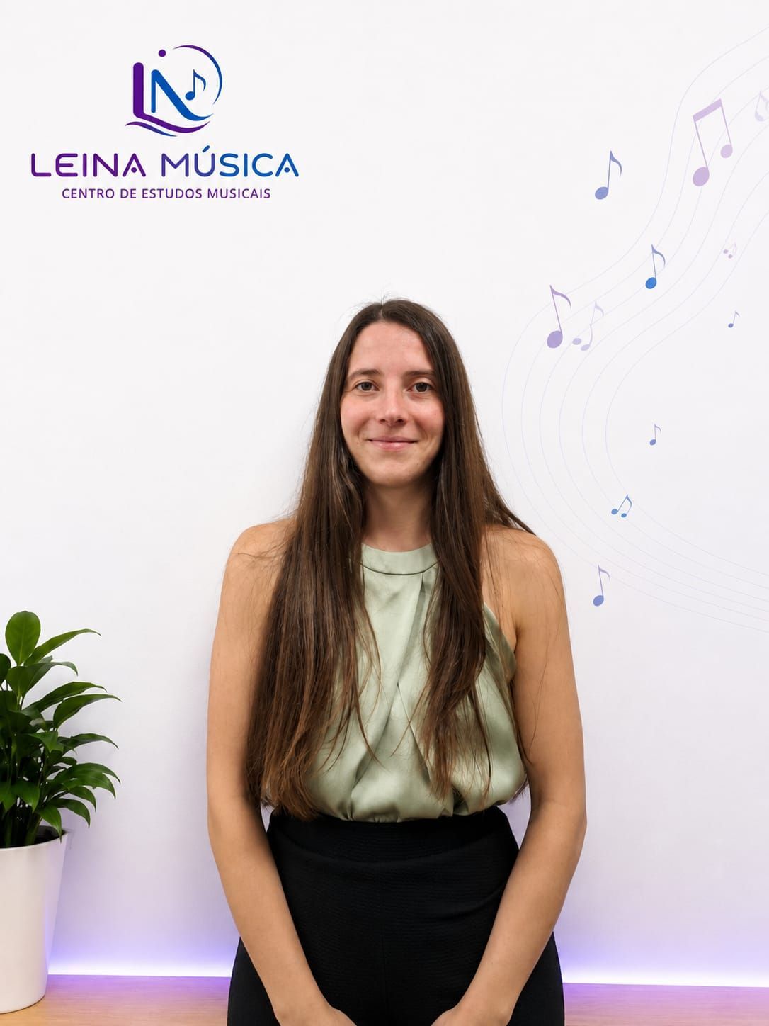 Mujer de pie frente al logo de Leina Música, sonriendo en un estudio luminoso con vinilos decorativos