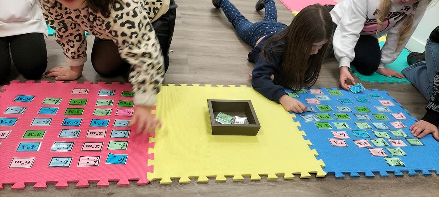 En una actividad en el aula, los niños se arrodillan sobre coloridas esterillas de espuma