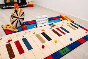 Rueda giratoria de premios sobre una mesa llena de coloridas cajas de manualidades y juegos en una habitación.