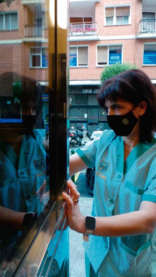 Una mujer que lleva una máscara está mirando por una ventana.
