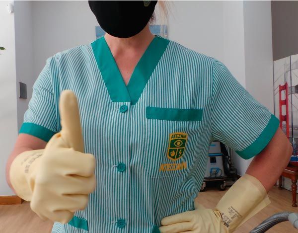 Una persona que lleva una máscara y guantes haciendo un gesto de aprobación con el pulgar hacia arriba