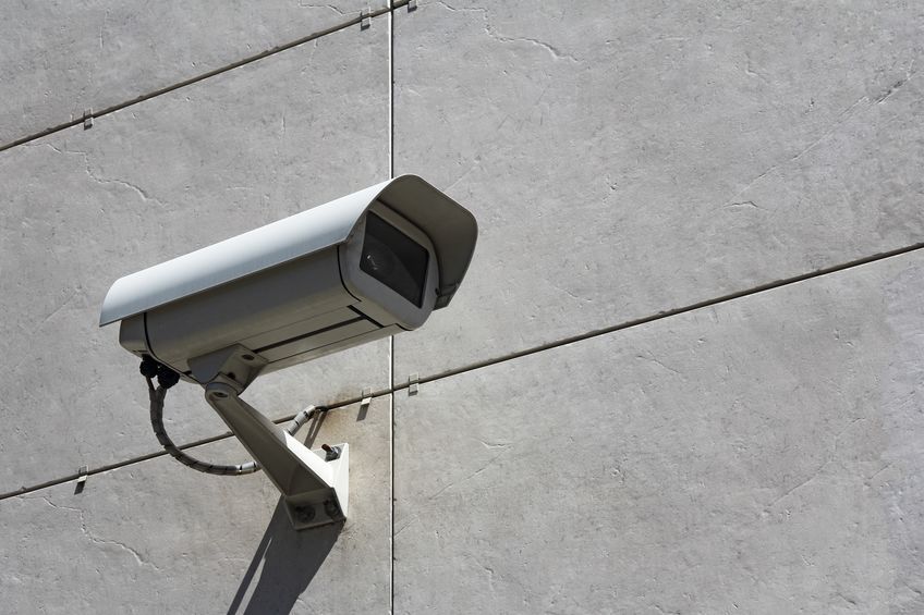 Una cámara de seguridad está montada en el costado de un edificio.