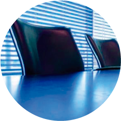 Un círculo con una mesa azul y sillas dentro.