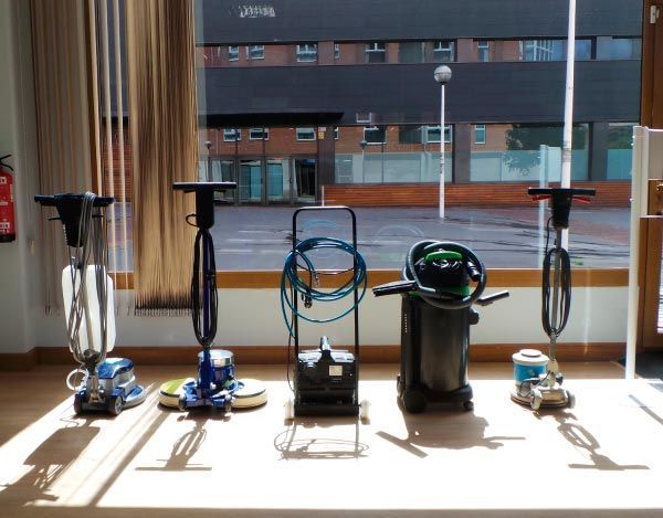 Tres aspiradoras están alineadas en una mesa frente a una ventana.