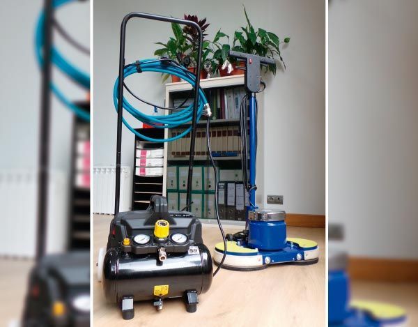 Una aspiradora está colocada sobre un piso de madera en una habitación.