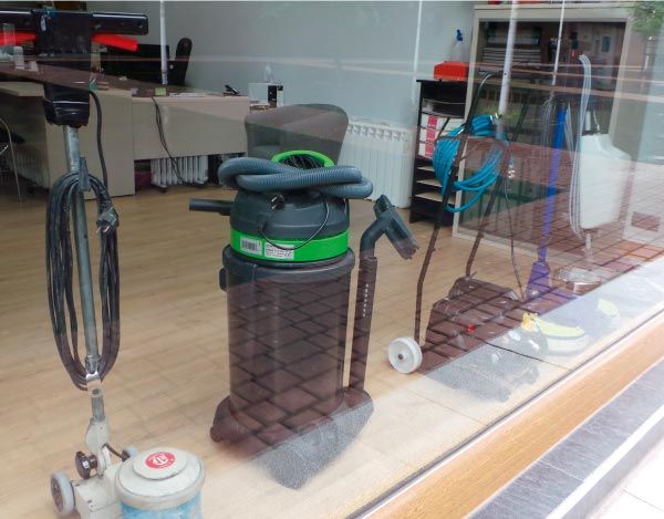 En el escaparate de una tienda se muestra una aspiradora con una raya verde.