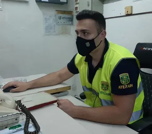 Un hombre que lleva una máscara está sentado en un escritorio.