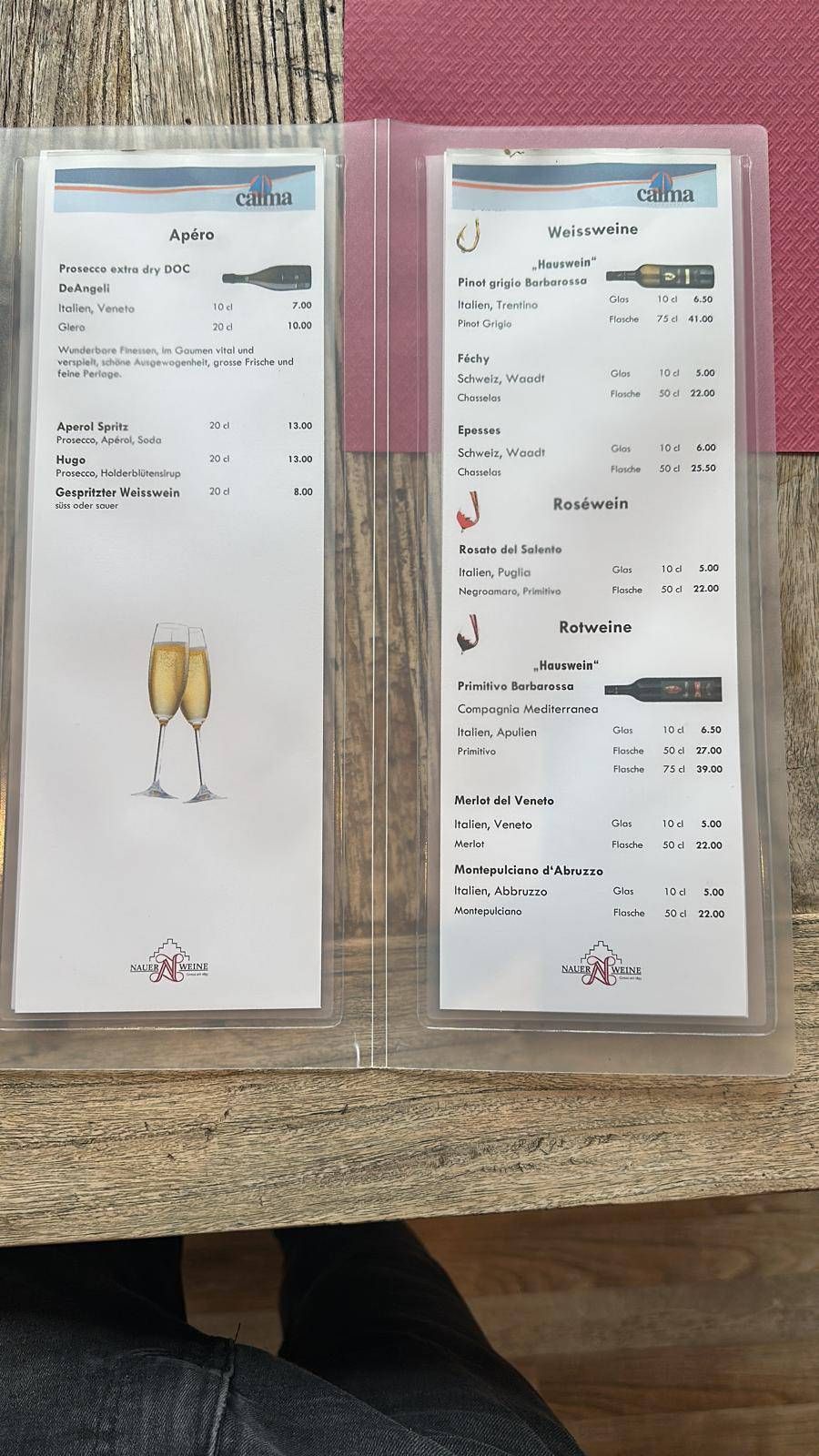 Zwei gedruckte Quittungen auf einem Holztisch, eine davon mit der Abbildung eines Champagnerglases.