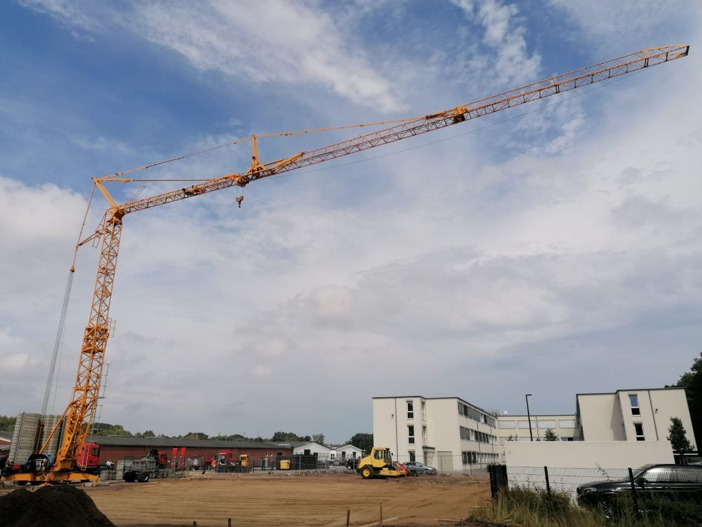 Eine Baustelle mit einem großen gelben Kran im Vordergrund