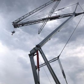 Ein großer Kran steht vor einem bewölkten Himmel.