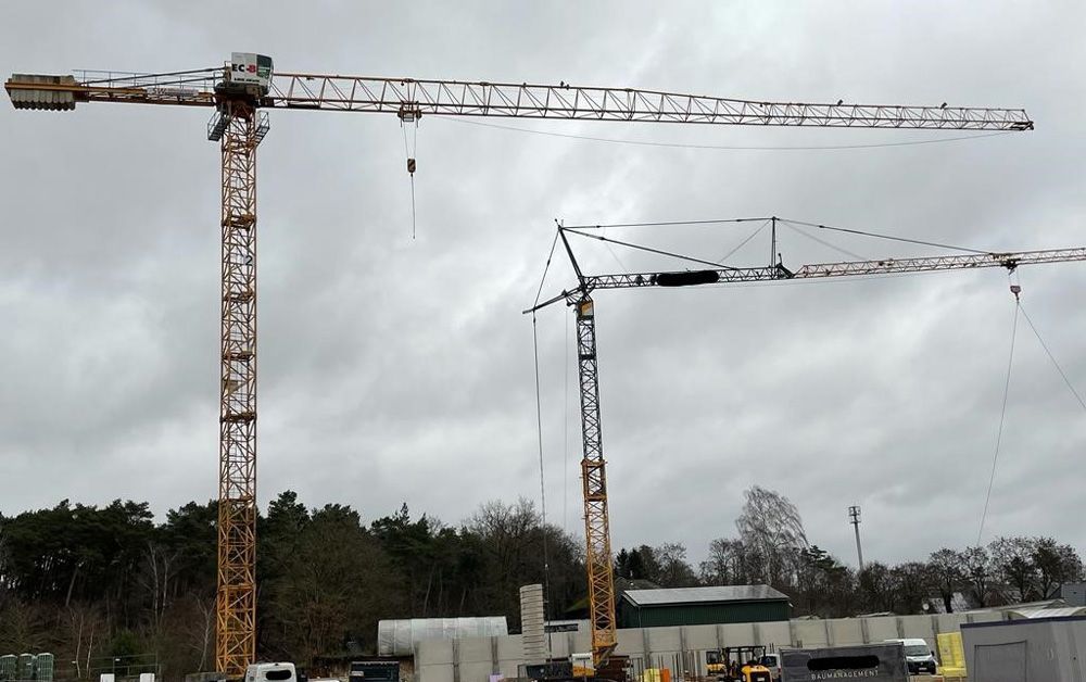 Zwei Baukräne arbeiten auf einer Baustelle