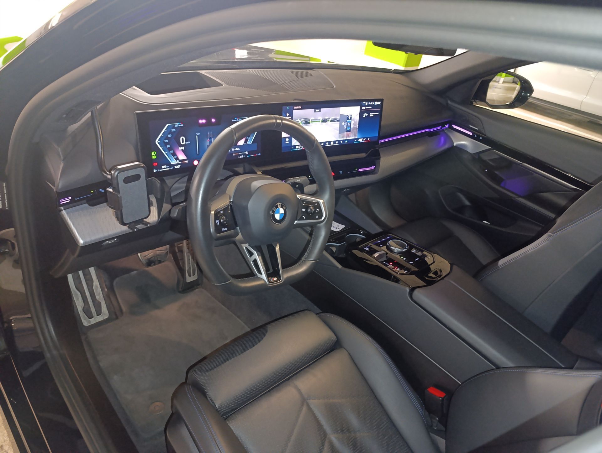 Luxuriöser Fahrzeuginnenraum mit schwarzen Ledersitzen, Lenkrad und digitalem Armaturenbrett.