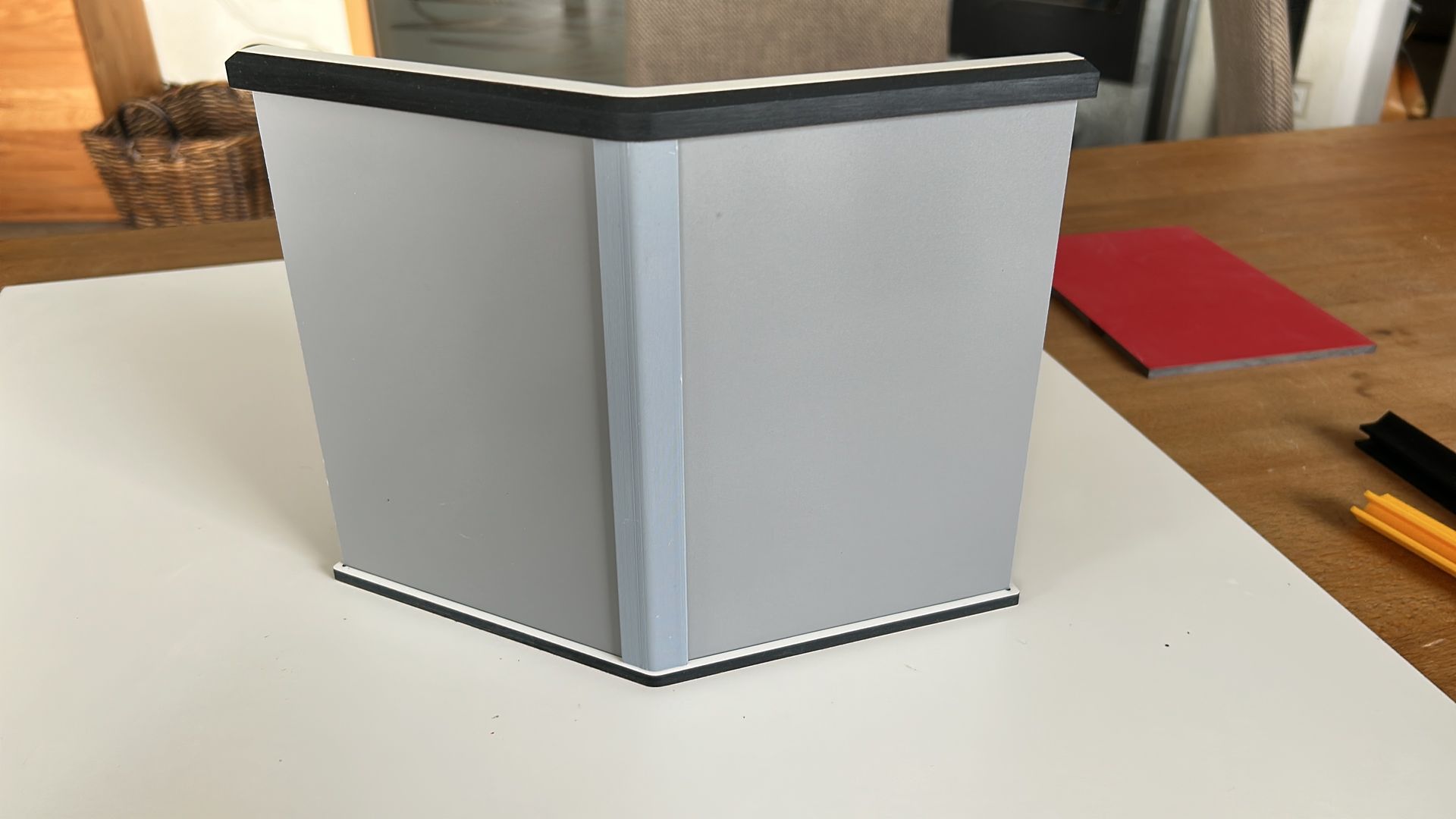 Auf einem weißen Tisch steht eine graue Kiste.